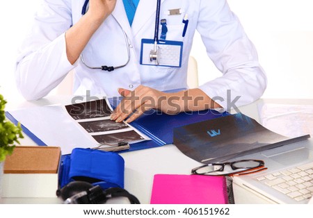 Portrait of young female doctor sitting at desk in hospital