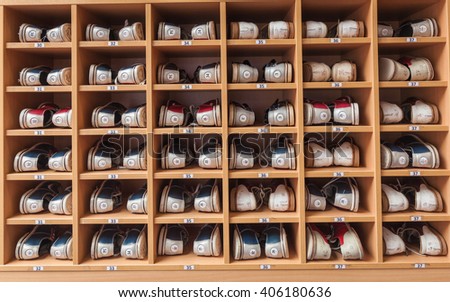 Bowling shoes in a shoe cabinet sorted by size