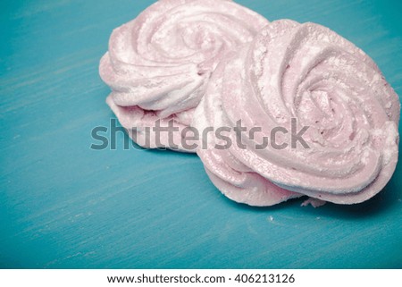 Fresh pink homemade zephyr - marshmallow on blue wooden table. Shallow depth of field. Toned.