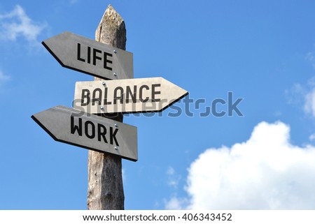 "Life, balance, work" - wooden signpost, cloudy sky