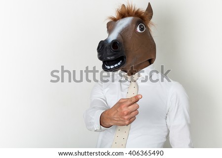 Businessman portrait wearing horse head and finger-pointing Royalty-Free Stock Photo #406365490