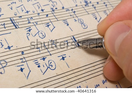  Hand with pen and music sheet - musical background