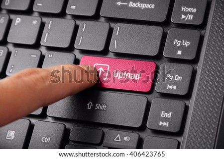 A finger gesturing to click the UPLOAD button on a laptop keyboard