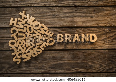 Make your own brand. The word "Brand" is lined with wooden letters on wood planks of table. Photo image Royalty-Free Stock Photo #406455016