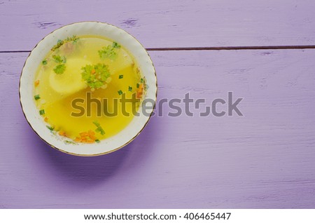 clear soup with vegetables in plate on wooden table .Rustic style. Top view. Free space for text.