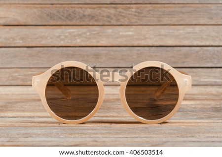 Sunglasses on wooden texture.