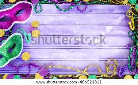 Vibrant Mardi Gras background with masks, beads and coins and copy space
