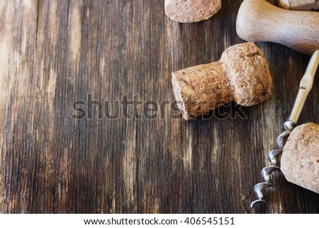 Old corkscrew for wine and wine corks on a vintage wooden background. Close-up. Toned image. Selective focus. Copy space background