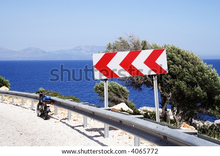 "steep turn" sign on a coastline road