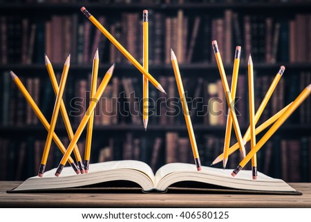 Pencil floating on the heavy books