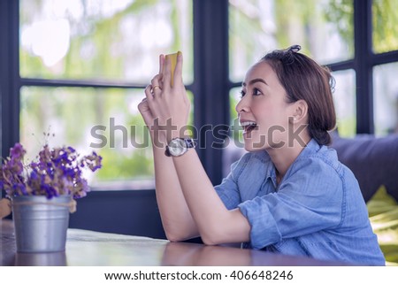 Beautiful young Asian woman being looking at phone seeing surprised message news or photos there with disgusting emotion on her face Royalty-Free Stock Photo #406648246