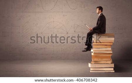 A serious businessman with tablet in hand in suit sitting on a pile of giant books in front of a greyish brown wall including drawn lines, angles, numbers, circles and curves.