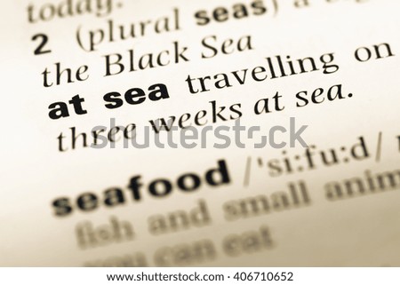 Close up of old English dictionary page with word at sea