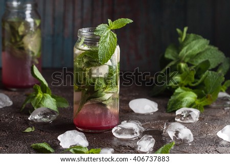 Homemade guava mojito with fresh mint, lime juice and ice on the old dark blue background