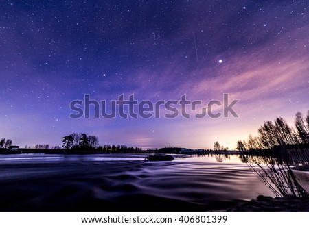 Nightly reflections by the river at springtime Royalty-Free Stock Photo #406801399