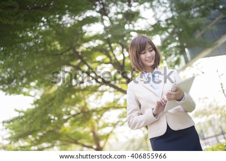 Attractive asian business woman working on tablet computer outside Office