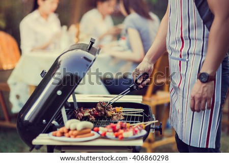 Asian men are cooking for a group of friends to eat barbecue Royalty-Free Stock Photo #406860298