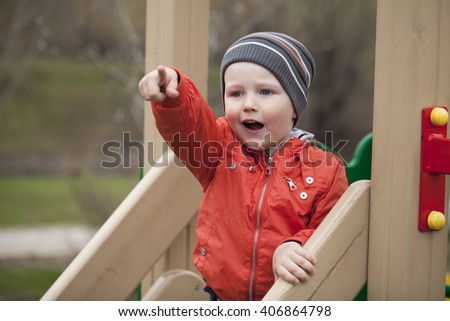 little boy climbing on children playground, spring outdoors