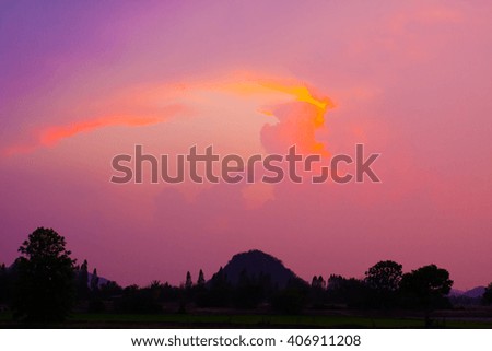 sunrise sunset twilight time colour scene tropical hills trees mountain view silhouette with small lake surrounding with green tropical natural environment in dark shadow under smooth cloudy sky
