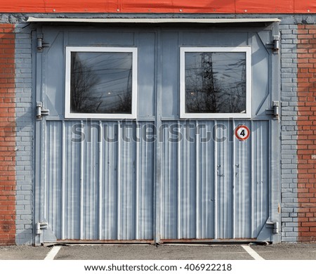 Old gray metal garage gate with square windows, background photo texture