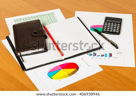 Calculator, notepad, pen and pencil on the background of the desktop.