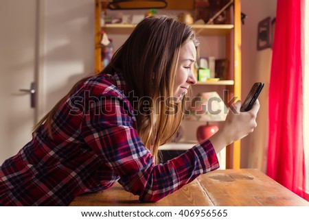 A young girl is not happy and looking her smart-phone