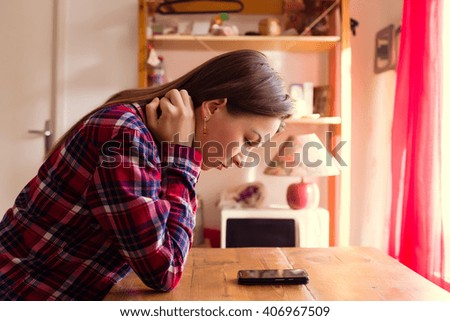 Young woman is waiting for a call or message and looking at her phone