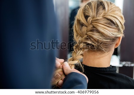 Cropped Image Of Hairdresser Braiding Client's Hair Royalty-Free Stock Photo #406979056