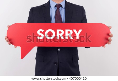 Businessman holding speech bubble with a word SORRY
