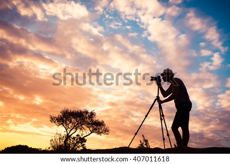 Male photographer taking photos in a beautiful nature setting.  Royalty-Free Stock Photo #407011618