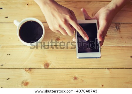 Close Up image of woman's hands holding mobile phone  sitting in coffee shop.