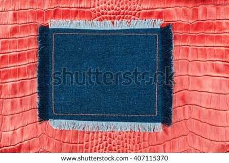 Frame made of denim with a fringe is on the red crocodile skin, with space for your text