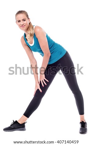 Young fitness woman bending down, exercising.