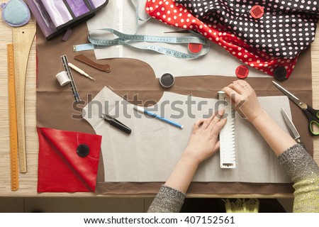 Desk designer fashion. Fashion designer starts cutting fabric to create fashionable clothes. Royalty-Free Stock Photo #407152561