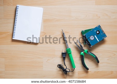 Repair tool,hard disk and notepad on wood table.