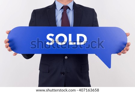 Businessman holding speech bubble with a word SOLD