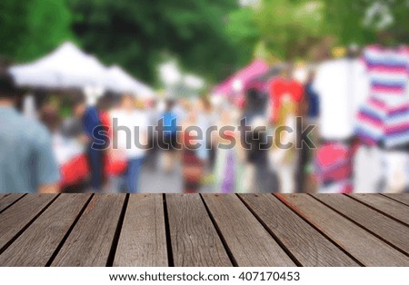 blurred image wood table and abstract walking street at market