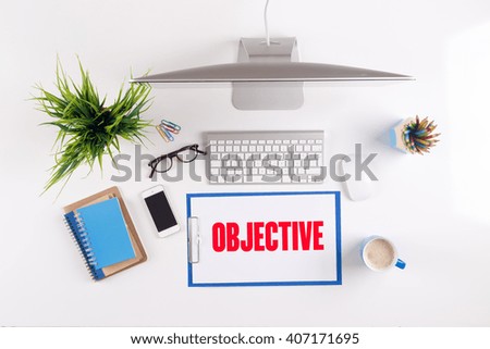 Office desk with OBJECTIVE paperwork and other objects around, top view