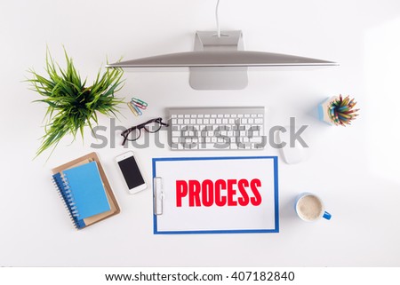 Office desk with PROCESS paperwork and other objects around, top view