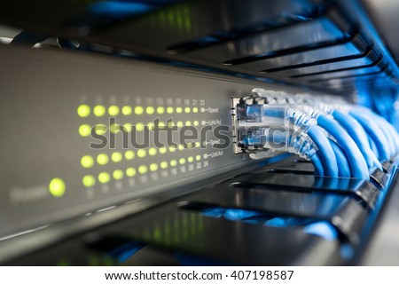 Network switch and ethernet cable in rack cabinet. Network connection technology and has a status LED to show working status. Concept of infrastructure with cables connected to data center Royalty-Free Stock Photo #407198587