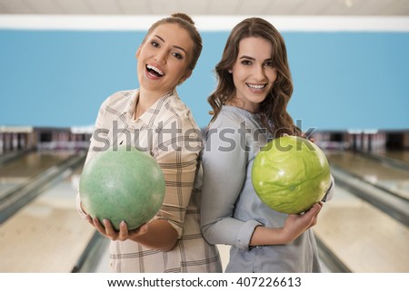 Female best friends in bowling club
