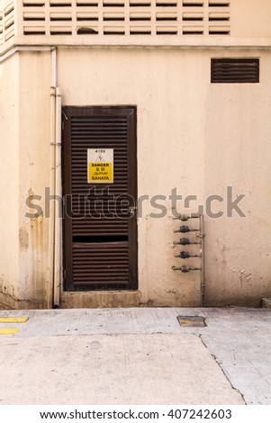 Shop house back door with danger high voltage sign 