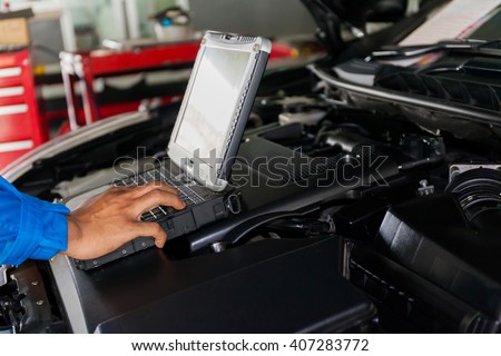 Mechanic using Diagnostic machine tools ready to be used with car Royalty-Free Stock Photo #407283772
