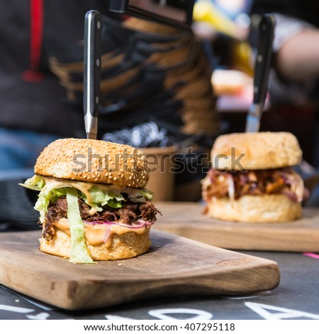 Beef burgers being served on food stall on open kitchen international food festival event of street food. Royalty-Free Stock Photo #407295118