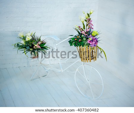 retro bicycle with flowers in Cart on a light background