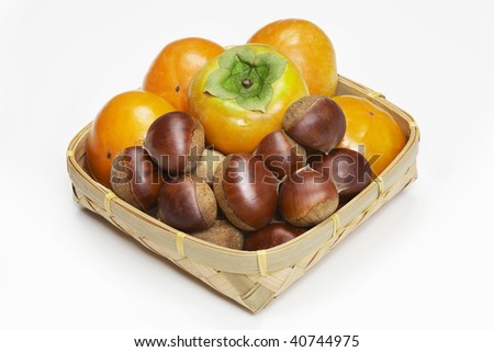 A lot of persimmons and chestnuts in the basket.