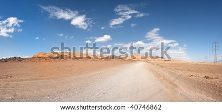 Road in the desert towards the distant rocks
