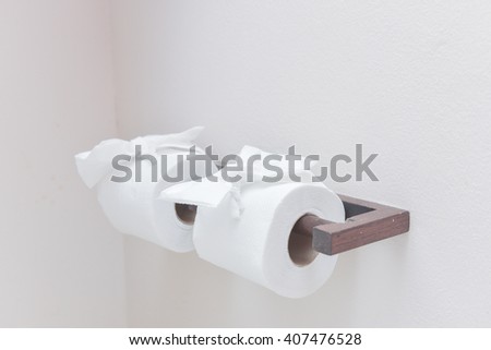 A roll of white toilet paper hanging in toilet room
