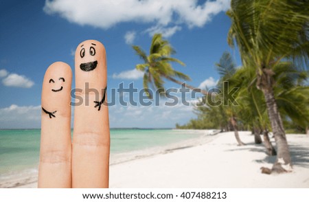 family, travel, summer holidays, tourism and body parts concept - close up of two fingers with smiley faces over exotic tropical beach with palm trees background