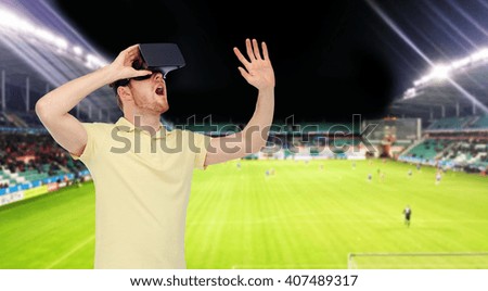 3d technology, virtual reality, sport, entertainment and people concept - happy young man with virtual reality headset or 3d glasses playing game over football field on stadium background